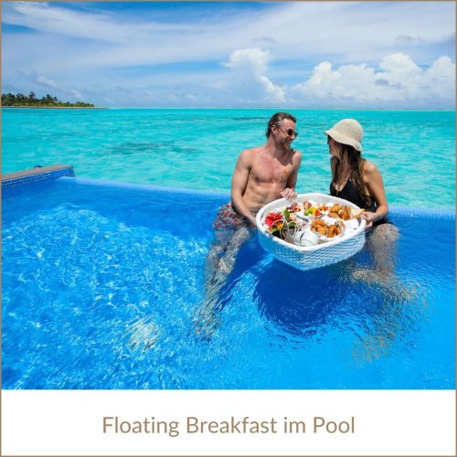 Erfurt REISEBÜRO Wache: Malediven Urlaub buchen; im Bild: Paar im Pool, vor sich ein Tablett mit hohem Rand und Frühstück darauf, sog. floating breakfast. Im Hintergrund das türkisfarbene Meer