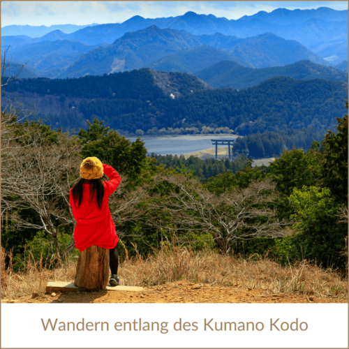Japan Rundreise buchen bei REISEBÜRO Wache Erfurt; im Bild: Frau auf einem Stein sitzend und von einem Hang auf eine bergige, im Hintergrund blau werdende Berglandschaft schauend; Text: Wandern entlang des Kumano Kodo