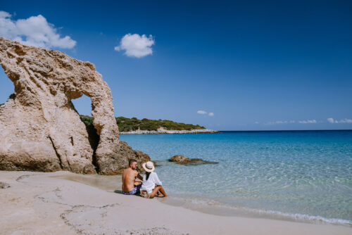 Kreta Urlaub Adults only buchen beim REISEBÜRO Wache, Erfurt; im Bild: Pärchen am Strand von Kreta, Griechenland, weißer Sand, im Hintergrund helle Felsen
