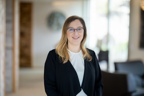 REISEBÜRO Wache – TEC Erfurt: Reiseberaterin Sabine Amberg, zu sehen: Frau mit halblangen, in den Spitzen blonden Haaren, dezenter Brille, offenem Blick, lächelndem Mund